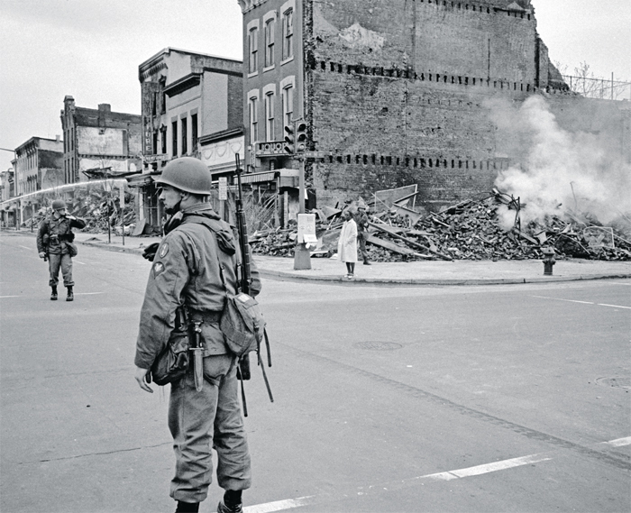 A soldier guarding the ruins of a building destroyed during the riots following Martin Luther King Jr.’s assassination, Washington, DC, April 8, 1968.