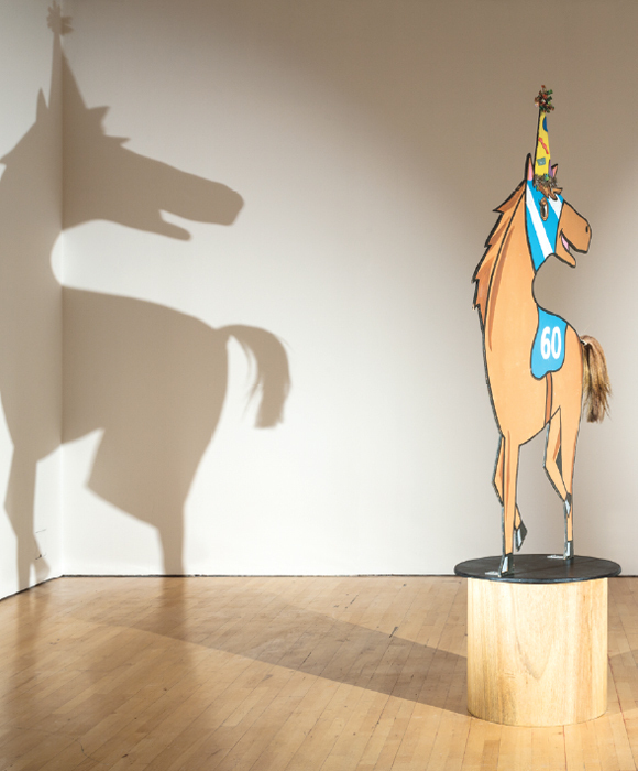 Lutz Bacher, Horse/Shadow, 2010–12, plywood, paint, ribbon, horsehair, pedestal with motor, lights, 78 x 36 x 1/4".