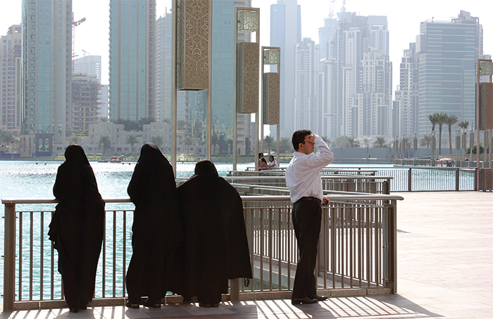 Pedestrians on a waterfront promenade in downtown Dubai.